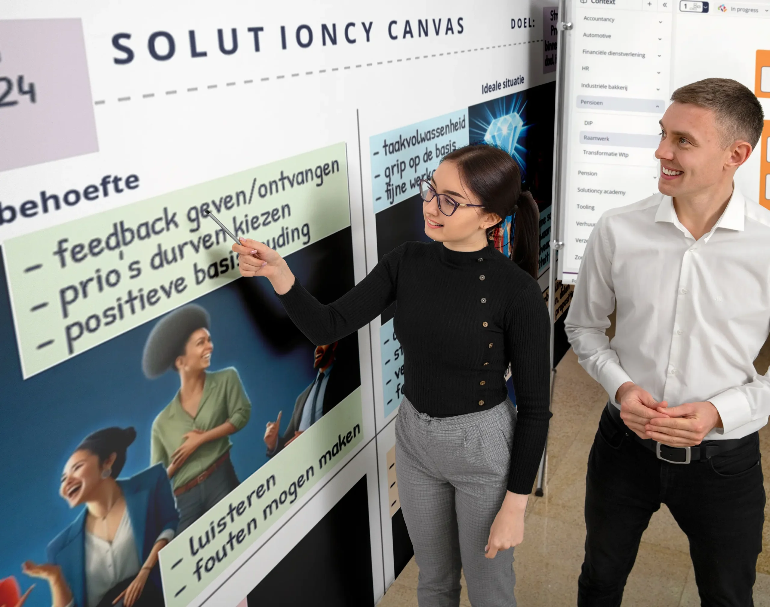 Twee professionals staan in een dynamische werkruimte. Een vrouw in een zwarte coltrui en grijze broek wijst met een pen naar een groot 'Solutioncy Canvas' aan de muur, waarop strategieën en werkmethoden zijn uitgeschreven in verschillende kleursecties. Naast haar staat een man in een wit overhemd die met een glimlach toekijkt. Er is een gevoel van teamwork en engagement terwijl ze samenwerken aan bedrijfsontwikkeling en probleemoplossing. De sfeer is positief en de focus ligt op samenwerking en het delen van ideeën.