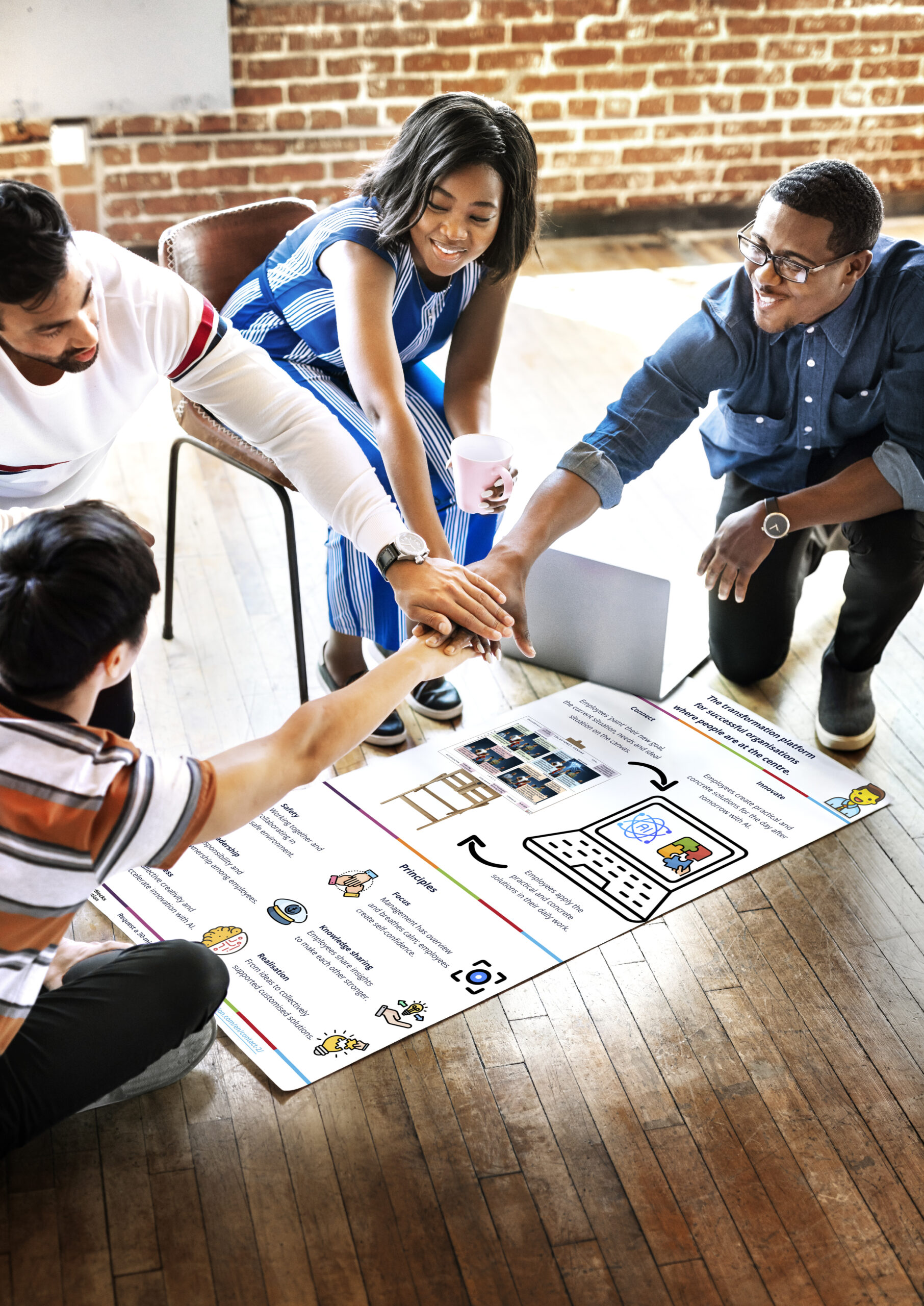 Diverse team stacking hands over a project plan mockup